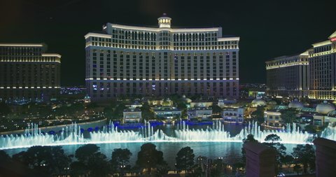 Las Vegas March 2021. Night life with street entertainments and attractions 4k. Night show of illuminated dancing fountains with world famous Bellagio hotel on background. Resort casino on the Strip