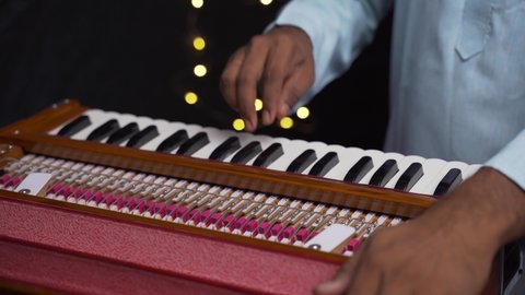 A closeup of hands playing harmonium very quickly in 4K