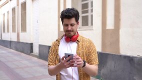 A slow-motion of a cool Spanish man with headphones dancing on the street in HD