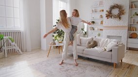 Young happy mother caucasian mommy babysitter woman holding in arms hands toddler little daughter child kid small girl dancing together in living room to music whirl spinning sing song having fun - Powered by Shutterstock - Get 15% off with code: PIKWIZARD15