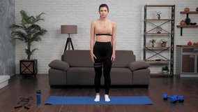 Young fit woman fitness trainer blogger in sportswear teaches students correct squat exercise. Muscular girl athlete talk records online remote webinar master class course lesson, workout at home