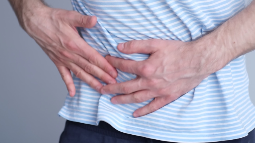 Side view of unhealthy man with Afro hairstyle feeling pain in stomach ...