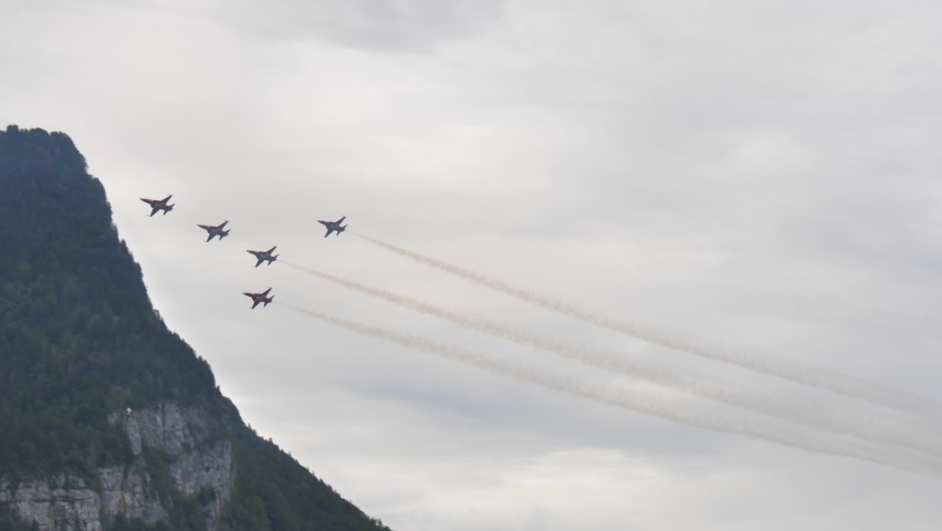 Mollis Switzerland 16 August 2019: Formation of combat jet aircrafts do a high speed low altitude pass with white smokes. Patrouille Suisse aerobatic team of Swiss Air Force six Northrop F-5E Tiger