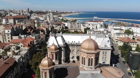Aerial view of houses by the sea with iconic church in the neighborhood, Drone view of city buildings near the sea