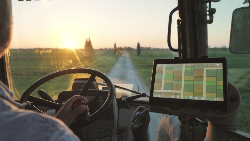 Farmer male driving tractor uses smart display touch screen application to check the fields of the farm,agriculture new technology app onboard of agricultural machine,modern farmhouse startup | Shutterstock HD Video #1070854882