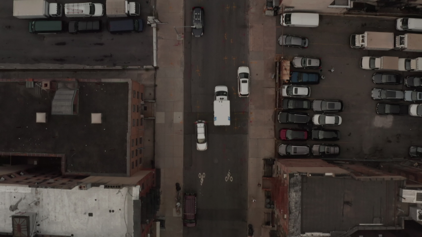Top down aerial overhead view of ambulance truck speeding through the streets of Chinatown neighborhood in New York City
