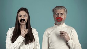 Party props. Couple having fun. Photo booth tool. Couple with with fake mustache and lips. Party concept. - Powered by Shutterstock - Get 15% off with code: PIKWIZARD15