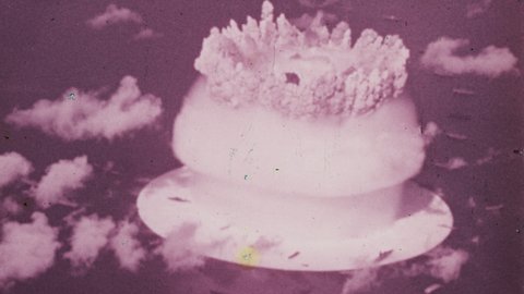 1950s Marshall Islands. The large Mushroom Cloud from the Explosion of a Nuclear Bomb dropped in the Pacific Ocean. 4K Overscan of Vintage Archival 16mm Film Print