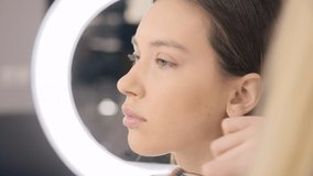 Close-up of a creative MUA applying face powder on a model. Beautiful woman prepares for a photoshoot. High quality 4k footage