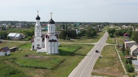 Aerial video of siberian village Burmistrovo in Summer season. View on Church of St. Vladimir Equal-to-apostles build in neo-russian style of modern church architecture. Siberia, Russia