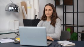 Serious woman involved in video conference online, using laptop computer for communication on the distance, female employee listening carefully the interlocutor, agrees and nods a head, video call