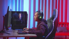 Male Child Using Headset Playing A Computer Game, Feeling Good During Playing Game
