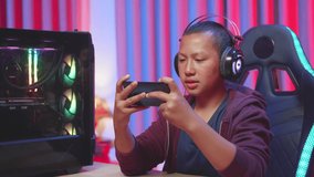Child Gamer Wearing Headphones Losing Video Game With His Smartphone
