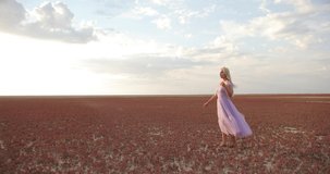 Romantic and carefree young woman in slow motion video standing on field enjoying freedom and calmness on nature.