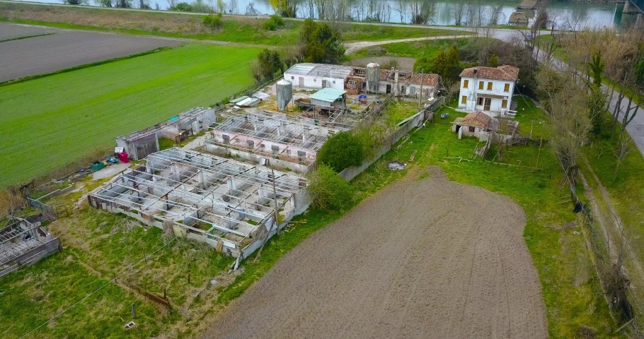 Aerial view of a ruined and abandoned factory among green fields