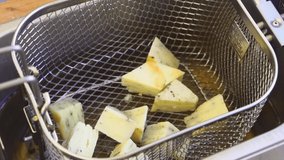 Thick cut chips being dunked into deep fat fryer - Powered by Shutterstock - Get 15% off with code: PIKWIZARD15