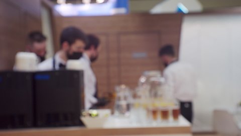 Modern small business.Silhouettes of several unrecognizable waiters in the same uniform working in a cafe.Blurred defocused video.Screensaver or background on a business theme.