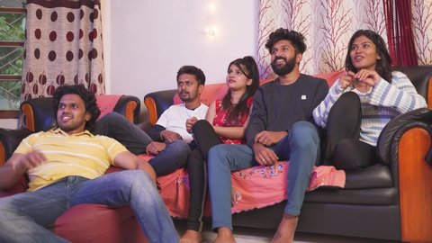 Group of Indian fans shouting and cheering up to support the team while watching sports on tv at home