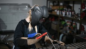 Video of a cute caucasian woman welder working with in a production