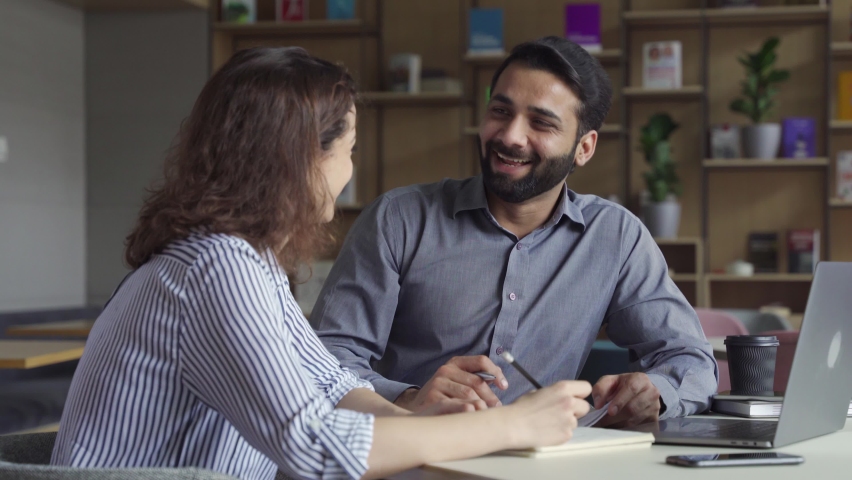 Two happy diverse business people professional employees workers having fun discussion working together laughing at office meeting. Indian teacher and latin student having friendly conversation. Royalty-Free Stock Footage #1070928709
