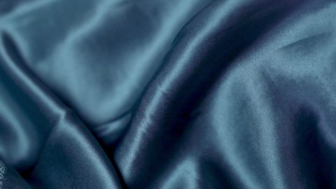 Smooth Natural Shiny Blue Silk Fabric, Smooth Silk Texture Of Fashion Clothes, Underwear, Close-up. Blue Shiny Silk Material. Clothing Factory. Textile Industry. Abstract Background of Silk Fabric.
