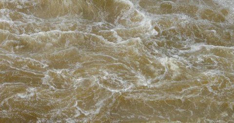 Raging and frothy water of the Ottawa River as it pours down stream from the Hydro Dam off of Chaudière Island in Ottawa, Ontario, Canada.