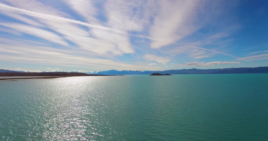 Beautiful Lake in Patagonia Argentina, El Chalten. Aerial drone shot of the breathtaking nature of South America. slow-flying over blue waters. sun reflecting and sparkling on sea. lago viedma