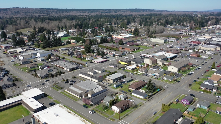 Cinematic aerial trucking drone clip of downtown Marysville, by the I-5 freeway, a distant suburb, bedroom community North of Seattle on the shores of Puget Sound in Washington