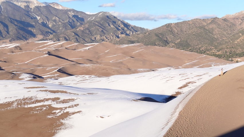 Panning shot of sand dunes and mountains