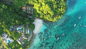 Dramatic top down aerial drone footage of the coast of Nusa Lembongan with many luxury villa and hotels in Bali, Indonesia, in early morning by an idyllic beach. 