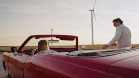 Tracking video of happy man jump in red convertible. Shot with RED helium camera in 8K.