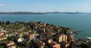Drone view of Passignano sul Trasimeno and its fortress, a charming medieval village on the lake Trasimeno, Umbria, Italy