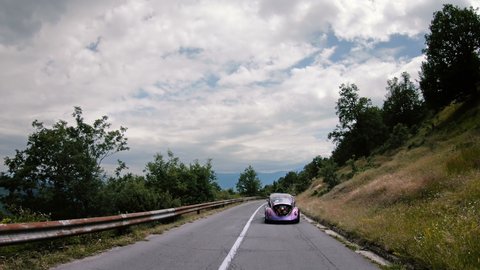 Kocani, Macedonia - 24 Jun, 2018: Classic custom VW Beetle driving on two lane road. Volkswagon cars participating in VW Ranch Run