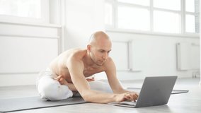 Young caucasian guy recording video on laptop, sit in bright modern studio, training alone. during coronavirus quarantine.