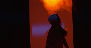Dancing young girl performing freestyle dance in colourful light in studio with smoke. Modern lifestyle, rap and hiphop