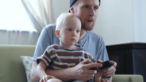 father and little son play console at home