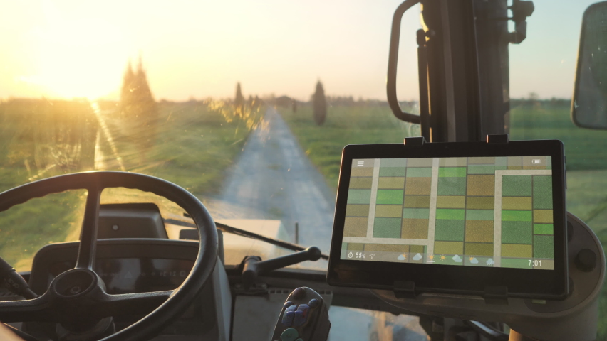 Smart agriculture technology farmer using tablet application in the tractor cab to optimize the harvest,man driving tractor using touch screen display to check fields production condition | Shutterstock HD Video #1070970955