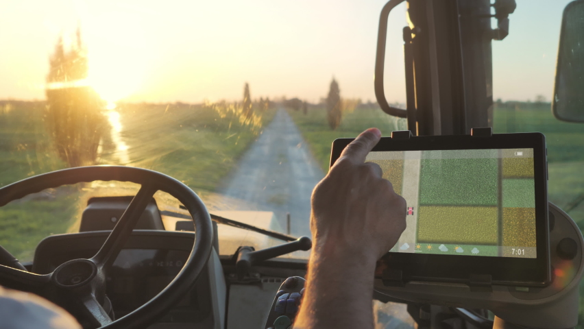 Smart agriculture technology farmer using tablet application in the tractor cab to optimize the harvest,man driving tractor using touch screen display to check fields production condition | Shutterstock HD Video #1070970955