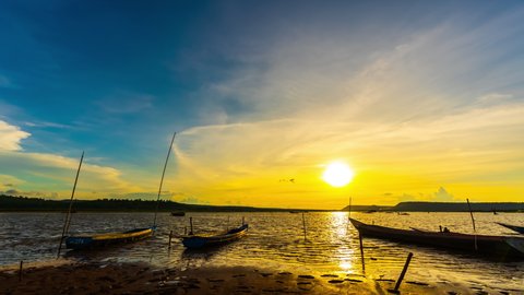 day to night time lapse of wooden boat at banks of the river with sunset in Khonburi, Nahon Ratchasima province, Thailand.