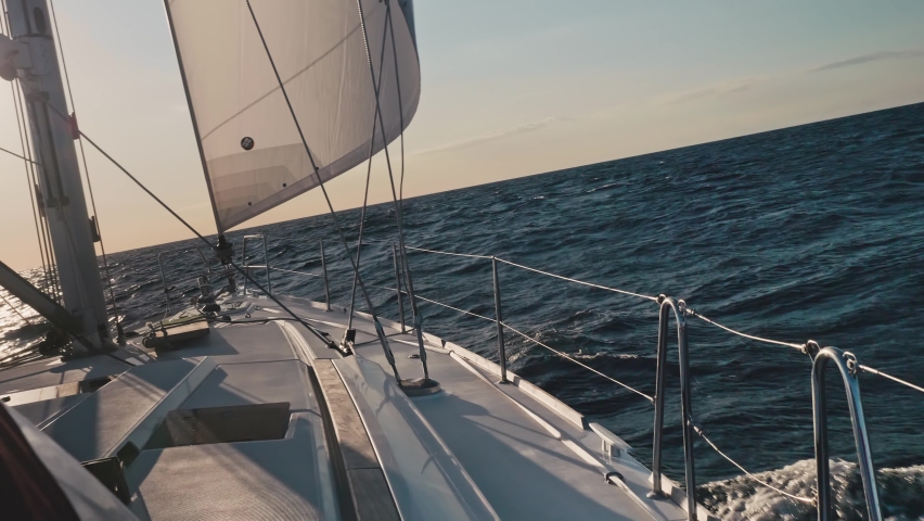 Breathtaking view of ocea water near yacht board. Water splashes making white foam. Yacht sailing in ocean.