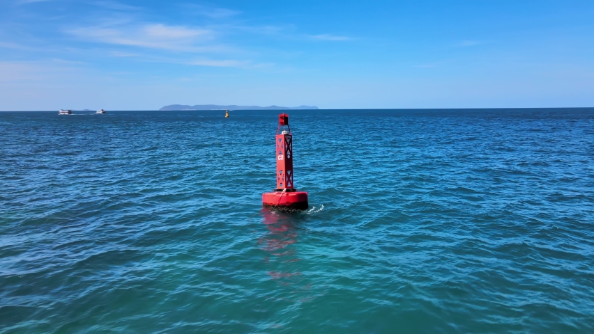 Aerial 4k drone footage circling a red buoy bobbling in the waves near the coastline of the exotic resort of Ko Larn, Thailand.  Royalty-Free Stock Footage #1070983768