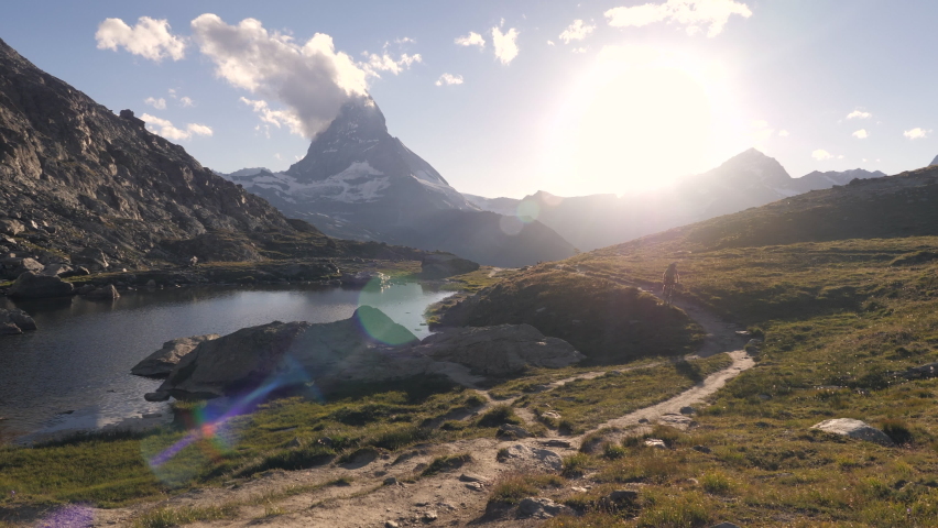 Man mountain biker rides along lake below the Matterhorn mountain 