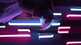 Vertical video - a virtual reality helmet on a woman close-up. Neon light. Futuristic future - Powered by Shutterstock - Get 15% off with code: PIKWIZARD15
