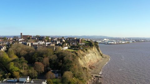 Penarth, Cardiff Bay and Docks, 4k drone footage. Shot captures the high eastern end of Penarth and the high cliffs around St Augustine's church - with Cardiff in the background. Static sunny shot