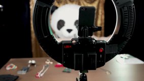 A woman dressed in a furry panda head costume dances on her social media video stream channel from her basement home studio.  	