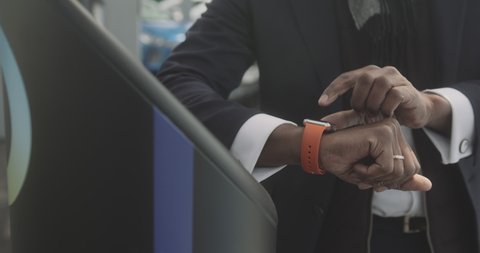 Close up of Business man using smart watch on console at electric charging station