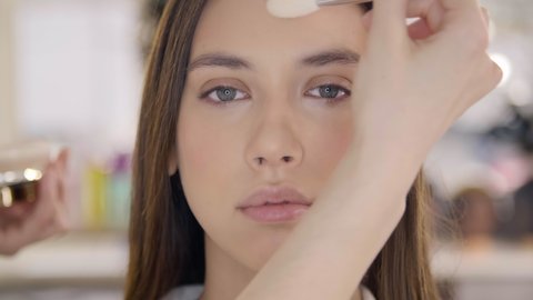 Makeup tutor shows how to apply face powder in a make-up school. Caucasian fashion model gets bridal make-up. High quality 4k footage