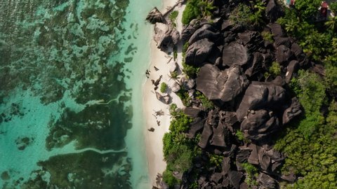 Dramatic scenic drone shot of La Digue island landscape, Seychelles. Tropical island paradise vacation honeymoon hotspot in Indian ocean. Bright summer sun, tourists, white sand beach, blue turquoise.