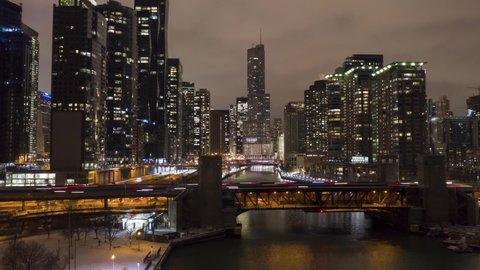 Urban Cityscape of Chicago City and Chicago River at Night in Winter. New Eastside and Streeterville. Aerial Hyper Lapse, Time Lapse. United States of America. Drone Flies Upwards