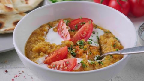 Vegan lentil soup with cilantro and tomato. Dal soup with tomatoes. Indian cuisine concept.